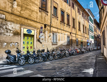 Les motos en stationnement sur rue étroite à Florence, en Italie, et entouré de vieux appartements. Banque D'Images