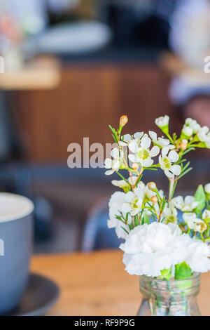 Petit pot de fleurs sur une table de café Banque D'Images