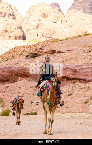 Un Bédouin est monté sur un chameau à Petra. Banque D'Images