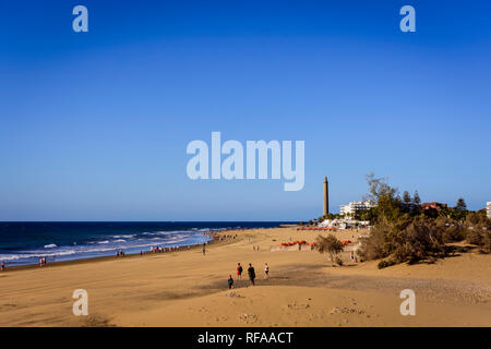 Les gens marcher sur les dunes de Maspalomas contre phare de Maspalomas en été Banque D'Images