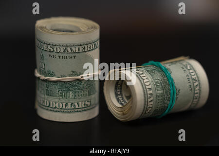 Deux rouleaux de billets en USD sur le noir dans un concept de richesse, succès , pot-de-vin, paiement, ou greffés Banque D'Images