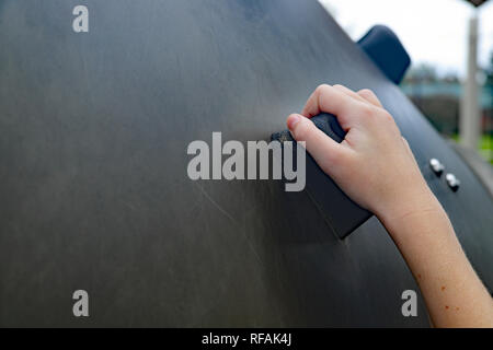 De l'enfant à l'extérieur sur un mur d'escalade à l'aire de jeux Banque D'Images