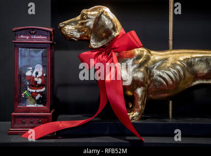 25 janvier 2019, Hessen, Frankfurt/Main : un teckel d'or et la sculpture d'édition miniature un Père Noël dans une cabine téléphonique Britannique sont parmi les idées de décoration à l'affiche au salon Christmasworld. Plus de 1000 exposants du monde entier présenteront les tendances et idées de décoration pour Noël à la foire du 25 au 29 janvier 2019. Photo : Boris Roessler/dpa Banque D'Images