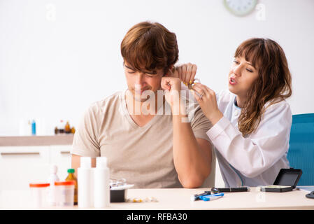 Patient avec problème auditif visiter médecin oto-rhino-laryngologiste Banque D'Images