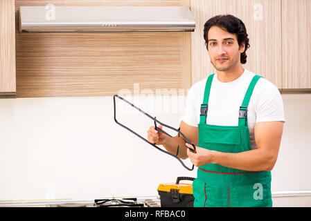 Jeune entrepreneur la réparation de four dans la cuisine Banque D'Images