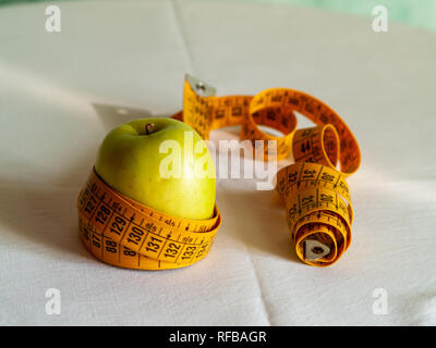 Concept de l'obésité. Une pomme verte et d'un ruban de mesure sur une table Banque D'Images