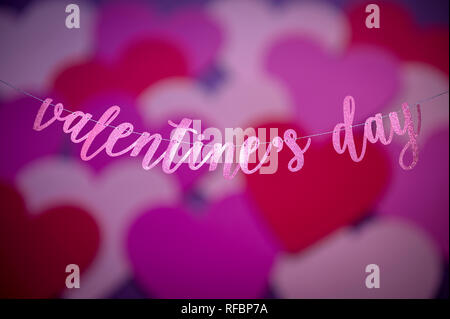 Valentine's Day Message dans script scintillants accroché dans une bannière avec abstract love heart overlay Banque D'Images