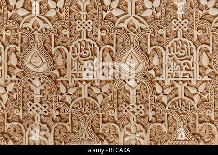 Les motifs géométriques complexes et détaillées et la calligraphie islamique d'un mur à sculpter le célèbre palais de l'Alhambra à Grenade, la forteresse- Espagne euro Banque D'Images