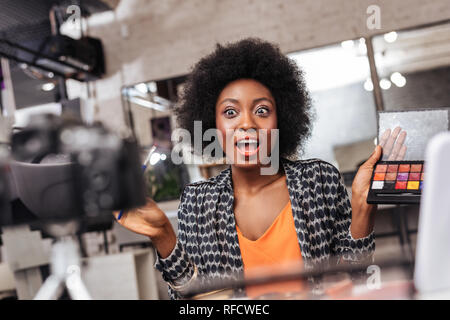 Belle de peau foncée african american woman avec les cheveux bouclés à la hâte Banque D'Images