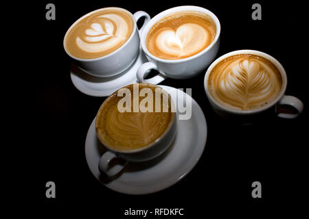 Latte art dessiné en forme de coeurs et fleurs sur le dessus d'une tasse de café. Banque D'Images