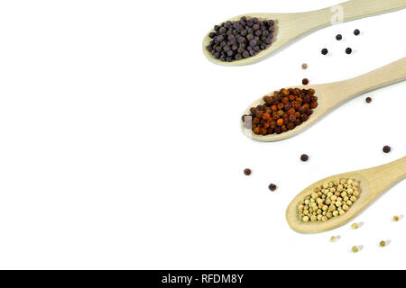 Noir, rouge et blanc en grains de cuillères en bois sur fond blanc isolé. D'épices naturelles et saveur culinaire concept Banque D'Images