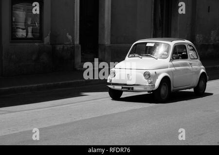 Fiat 500 blanc courant le long des rues de Matera - réduit à l'image noir et blanc Banque D'Images