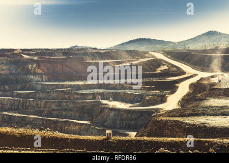 Riotinto mine à ciel ouvert avec des machines à travailler, où le cuivre et l'or sont extraites de sa carrière, avec le ciel et la forêt de pins à l'arrière-plan Banque D'Images