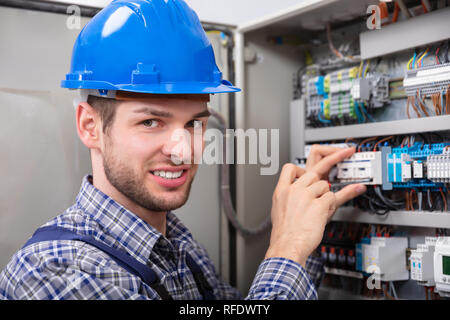 Technicien de réparation de fusibles à l'aide d'un tournevis Banque D'Images