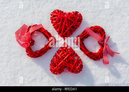 Quatre grands coeurs rouges sur la neige scintillante. Vilentine thème de la journée. Symbole d'amour. Banque D'Images