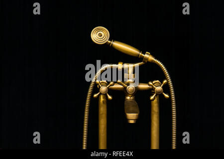 Vintage ancien robinet d'eau avec douche en laiton tête isolé sur fond noir Banque D'Images