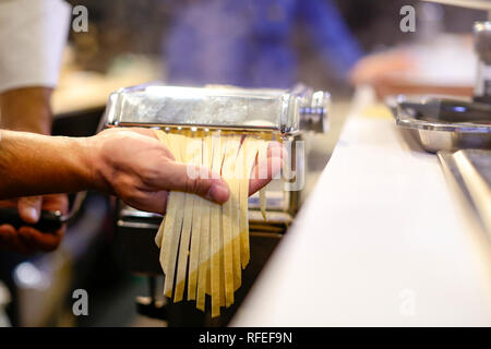 Chef faire des pâtes avec une machine, des pâtes fraîches faites maison Banque D'Images