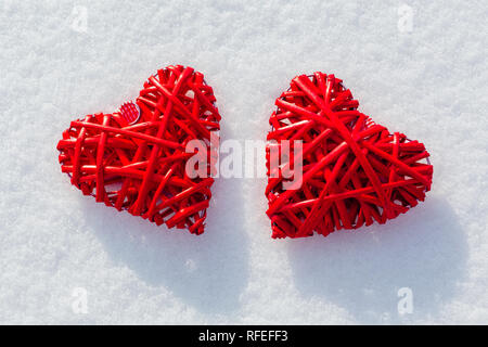 Deux gros cœurs rouges sur la neige scintillante. Vilentine thème de la journée. Symbole d'amour. Banque D'Images