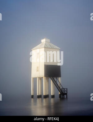 Le phare faible émergeant de la brume au petit matin. Burnham on Sea, Somerset Banque D'Images