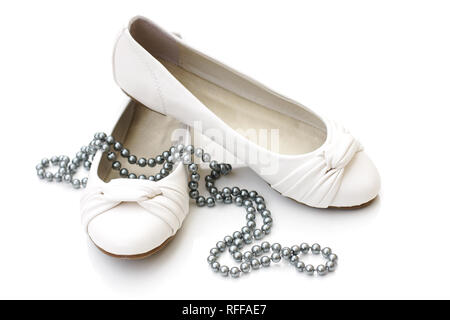 Chaussures dames blanc avec collier de perles d'argent sur fond blanc Banque D'Images