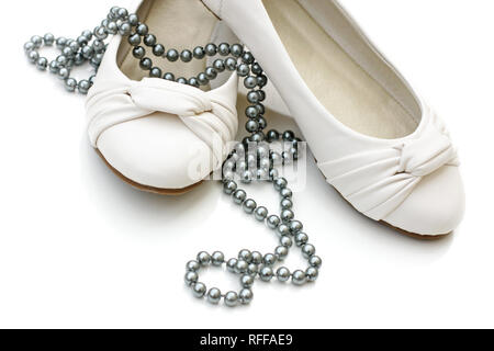 Chaussures dames blanc avec collier de perles d'argent sur fond blanc Banque D'Images