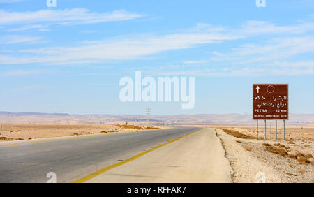 Kings Highway, belle route sinueuse qui traverse le désert de Wadi Rum avec un panneau routier indiquant la distance pour atteindre Pétra, en Jordanie. Banque D'Images