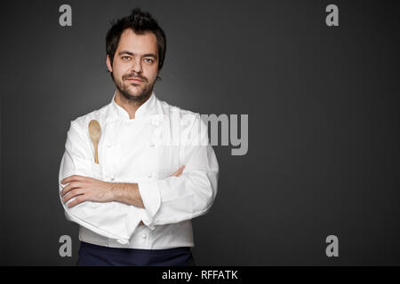 Beau chef posing contre l'arrière-plan gris Banque D'Images