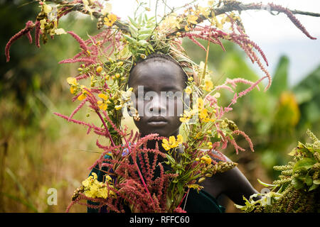 KIBISH, ÉTHIOPIE - 22 août 2018 : une femme non identifiée de Surmi tribu, avec décors naturels des congés et des fleurs dans une couronne. Surmi sont également ca Banque D'Images