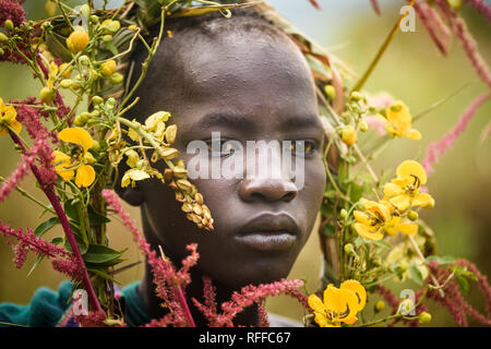 KIBISH, ÉTHIOPIE - 22 août 2018 : une femme non identifiée de Surmi tribu, avec décors naturels des congés et des fleurs dans une couronne. Surmi sont également ca Banque D'Images