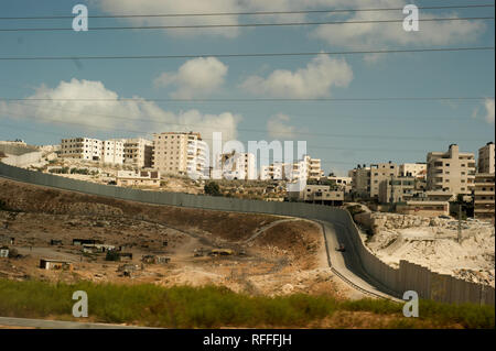 Petit village et ville palestinienne sur la colline derrière un mur de séparation en Cisjordanie, en Israël. Banque D'Images