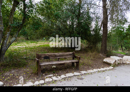 Un vieux banc de travers à côté de la clairière et près de la route dans le parc forestier de la ville Banque D'Images