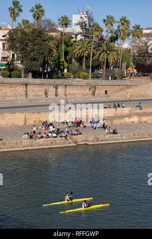 Deux personnes sur le kayaing Gudalquivir River, groupe de jeunes étudiants, flâner sur river front de mer dans la ville de Séville en Andalousie, Espagne Banque D'Images