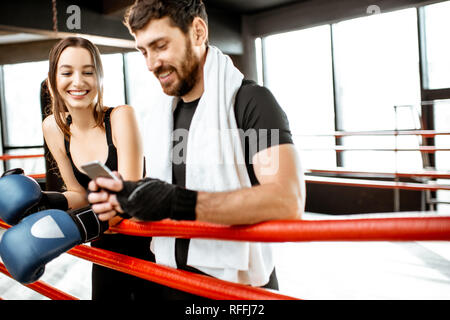 L'homme et la femme s'amuser ensemble pendant la pause après la formation sur le ring de boxe à la salle de sport Banque D'Images