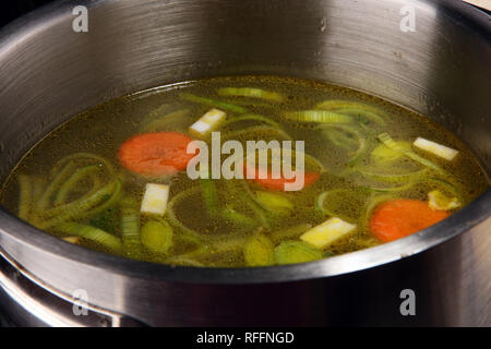 Bouillon avec carottes, oignons divers légumes frais dans un pot - frais colorés clear spring soupe. Cuisine végétarienne paysage rural bouillon Banque D'Images