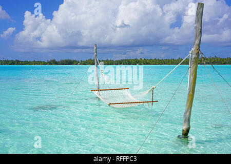 Hamac avec une vue, planté dans les eaux bleu azur du lagon de Bora Bora, Polynésie Française Banque D'Images