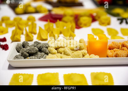Différents types de pâtes italiennes La collection. Différentes couleurs de pâte en vue dans les assiettes avec des bougies à partir de ci-dessus. Banque D'Images