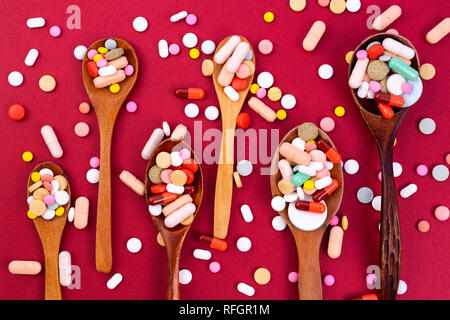 Colorés différents comprimés et gélules dans des cuillères en bois. L'industrie pharmaceutique mondiale pour des milliards de dollars par année. Les médicaments pharmaceutiques. O isolés Banque D'Images