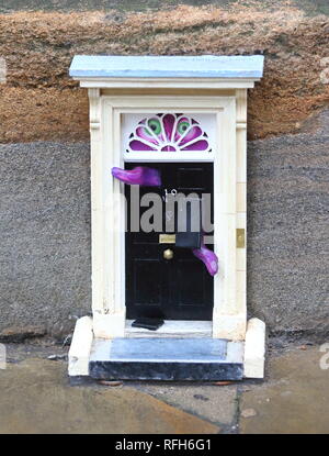 Cambridge, UK. 25 Jan, 2019. Une petite copie de la célèbre porte de la résidence du Premier ministre britannique, au 10, Downing Street, Londres vu par Downing Street, Cambridge. Mystère Les artistes de rue en passant par le pseudonyme de 'Dinky' portes sont responsables de l'installation, qui est la dernière d'un projet en cours. À ce jour il y a des 'dinky' portes à la réalité des prérequis sur l'Œuvre de Parker et le Teleport-O-Matic machine entre les boîtes de téléphone rouge par le grand l'église de Sainte Marie dans la ville. Credit : SOPA/Alamy Images Limited Live News Banque D'Images