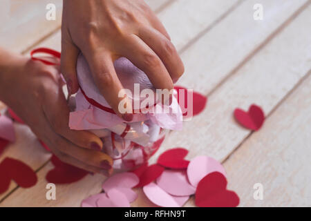 Lover's day. Pot en verre d'ouverture ou de date et désirs ou souhaits. Coeurs en papier rouge à l'arrière-plan. Banque D'Images