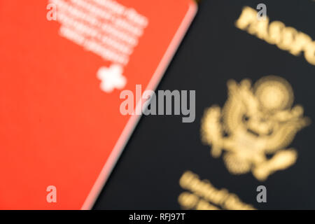 Close up unfocused vue d'un passeport suisse rouge et bleu un passeport américain Banque D'Images