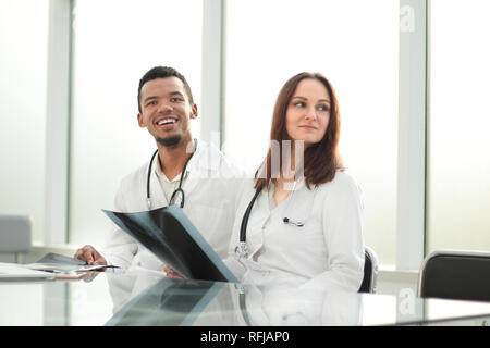 Collègues médecins avec x-ray assis au bureau 24 Banque D'Images