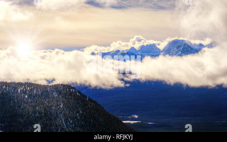 Vue aérienne de la Canadian Rockies' pics couverts de neige s'élevant au-dessus d'une mer de nuages au lever du soleil spectaculaire dans les montagnes rocheuses du parc national de Banff Banque D'Images