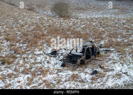 L'épave d'une voiture dévasté sur un pré. Voiture démonté squelette. Saison Hiver. Banque D'Images