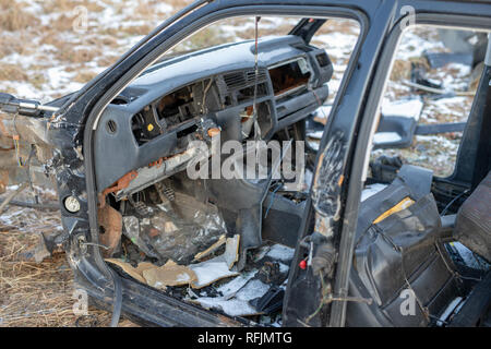 L'épave d'une voiture dévasté sur un pré. Voiture démonté squelette. Saison Hiver. Banque D'Images