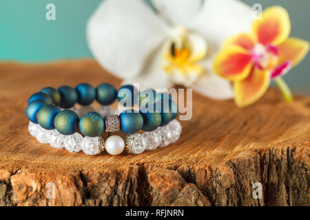 La femme exquise bracelets faits de pierres naturelles, de l'agate et quartz de sucre avec des accessoires qui sont incrustés de cubic zirconias. Close-up. Studio Banque D'Images