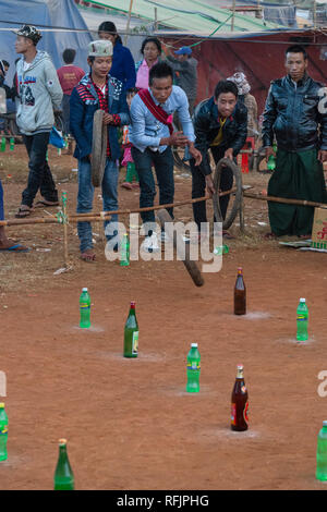 Un groupe de jeunes hommes jouent un amusant jeu juste d'avoir des pneus de vélo sur terre verre bateaux, Myanmar. Banque D'Images