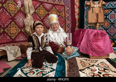 Grand-mère et petit-fils en costumes traditionnels à l'intérieur d'une yourte, Almaty, Kazakhstan Banque D'Images