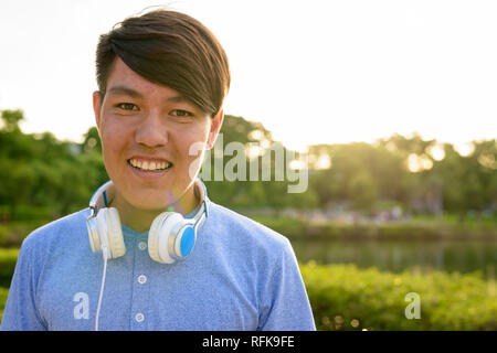 Young Asian Woman wearing headphones tout en vous relaxant à la Banque D'Images