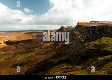 Randonnée pédestre vers le fameux arbre mort à Quiraing sur un jour d'automne ensoleillé avec passages nuageux ciel bleu et vue panoramique de Skye (Ile de Skye, Ecosse, Europe) Banque D'Images