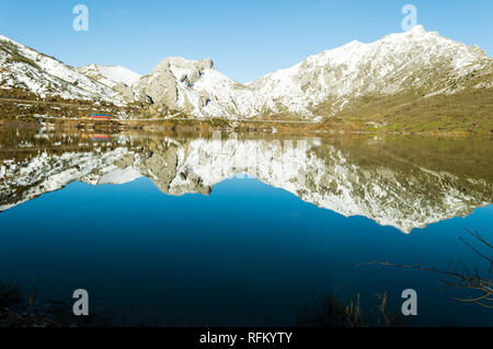 Les collines couvertes de neige se reflètent dans un lac de Barrios De Luna, Leon, Espagne, sur une belle soirée d'hiver Banque D'Images